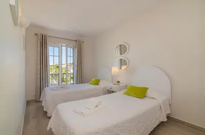 two beds in a white room with a window at The Old Village, Prestige and Solar by Village 4U in Vilamoura