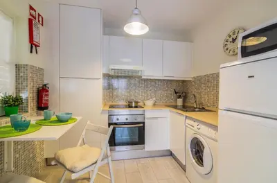 a kitchen with white cabinets and a washer and dryer at The Old Village, Prestige and Solar by Village 4U in Vilamoura