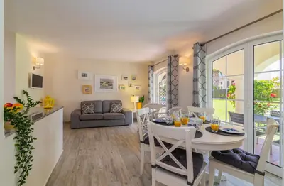 a kitchen and living room with a table and chairs at The Old Village, Prestige and Solar by Village 4U in Vilamoura