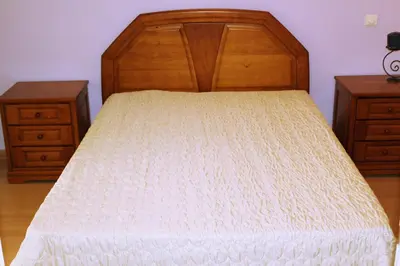 a bed with a wooden headboard and two night stands at Wonderful Villa in Albufeira