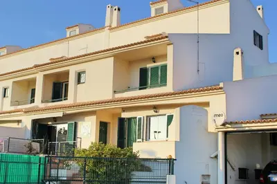 a large white building with green shutters at Wonderful Villa in Albufeira
