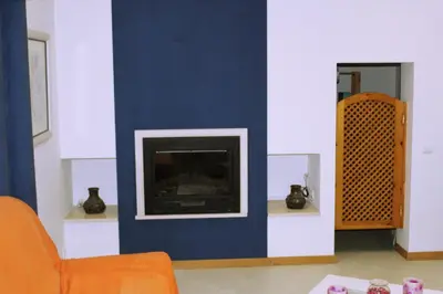 a living room with a blue wall with a fireplace at Wonderful Villa in Albufeira