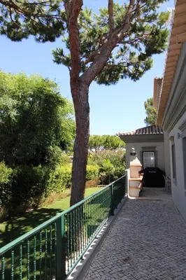 a tree on the side of a house with a fence at Charming Exceptional Golf Villa in Algarve in Faro