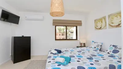 a bedroom with a bed and a window and a television at Nautilus 135- Clever Details in Vilamoura