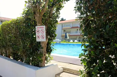 a sign on a tree next to a swimming pool at Nautilus 135- Clever Details in Vilamoura