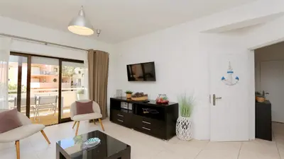 a living room with a couch and a table and a tv at Nautilus 135- Clever Details in Vilamoura