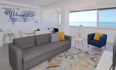 a living room with a gray couch and a blue chair at Paradise Quarteira in Quarteira