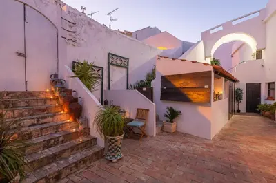 a building with stairs and potted plants in a courtyard at Casa dos Arcos - Charm Guesthouse in Albufeira
