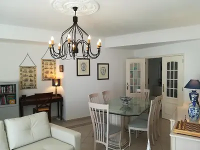 a dining room and living room with a chandelier at Porque Você Merece in Quarteira
