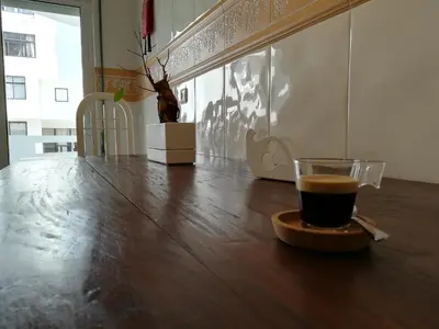 a cup of coffee sitting on a wooden table at Porque Você Merece in Quarteira
