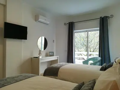 a hotel room with two beds and a window at Porque Você Merece in Quarteira