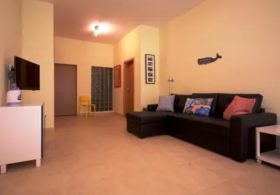 a living room with a black couch and a tv at Apartamentos Plaza - Albufeira in Albufeira