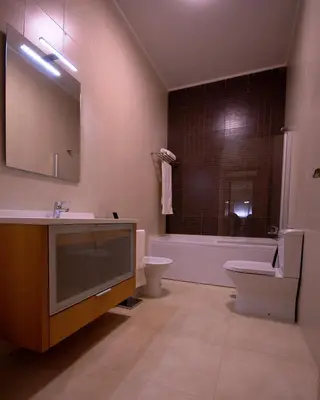 a bathroom with a sink and a toilet and a tub at Apartamentos Plaza - Albufeira in Albufeira