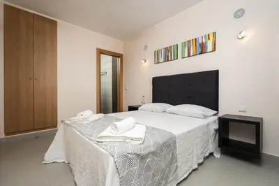 a bedroom with a large white bed with towels on it at Apartamento Yacintos in Albufeira