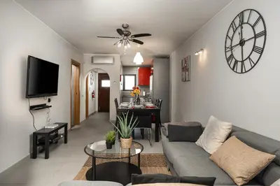 a living room with a couch and a clock on the wall at Apartamento Yacintos in Albufeira
