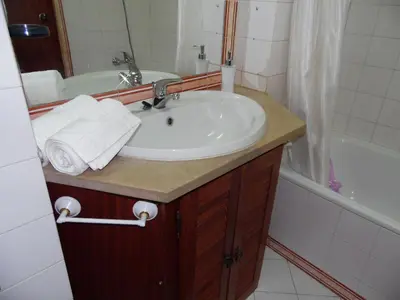 a bathroom with a sink and a bath tub at apartamento em albufeira in Albufeira