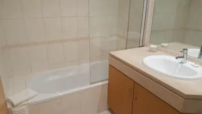 a bathroom with a sink and a bath tub and a sink at Vista das Ondas Apartment in Albufeira