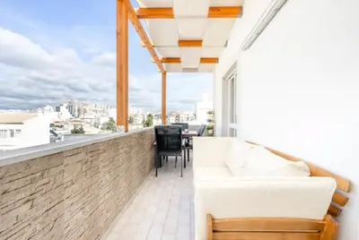 a balcony with a couch and a view of the city at My Place @ Faro Ria Views in Faro
