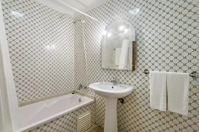 a white bathroom with a sink and a bath tub and a sink at Paula Bela by Garvetur in Quarteira