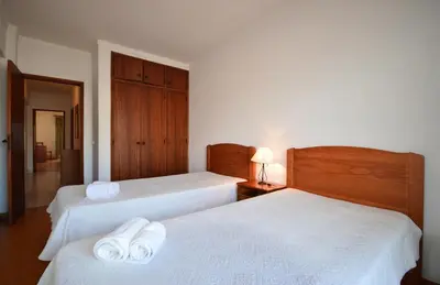 two beds in a hotel room with towels on them at Paula Bela by Garvetur in Quarteira