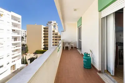 a balcony of a building with a blue fire hydrant at Paula Bela by Garvetur in Quarteira