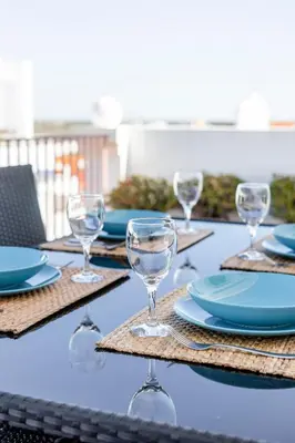 a table with plates and wine glasses on it at My Place @ Faro Duplex in Faro