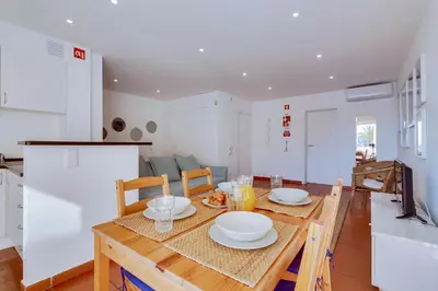 a kitchen and dining room with a wooden table and chairs at AL - Apartamento Vista Marina 1 in Vilamoura