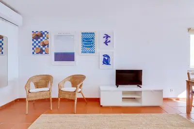 a living room with two chairs and a television at AL - Apartamento Vista Marina 1 in Vilamoura
