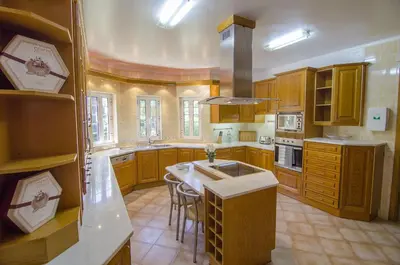a large kitchen with wooden cabinets and a sink at Villa Lira in Almancil