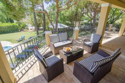 a patio with chairs and a table and a railing at Villa Lira in Almancil