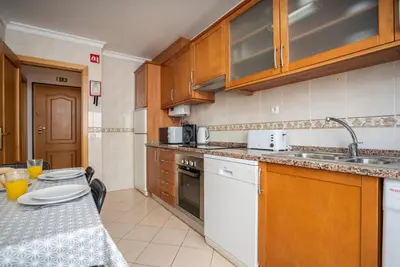a kitchen with wooden cabinets and a counter top at #001 Veríssimo Flat by Home Holidays in Albufeira