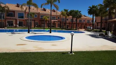 a large pool in a courtyard with palm trees and a building at Villa Jardins 2 by Sunny Deluxe in Albufeira