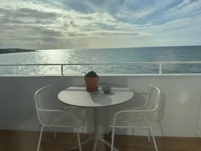 a balcony with two chairs and the ocean at Apartamentos Rossio Mar in Albufeira