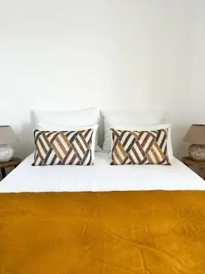 a white bed with two pillows on it at Apartamentos Rossio Mar in Albufeira