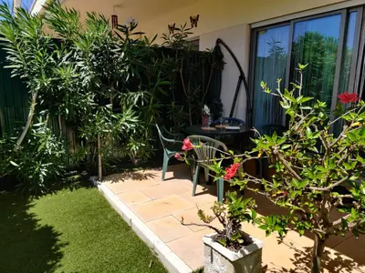 a garden with a table and a chair and some plants at Albufeira Monte Balaia in Albufeira