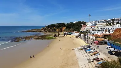 a beach with a bunch of chairs and the ocean at Vista das Ondas Olhos de Agua in Albufeira