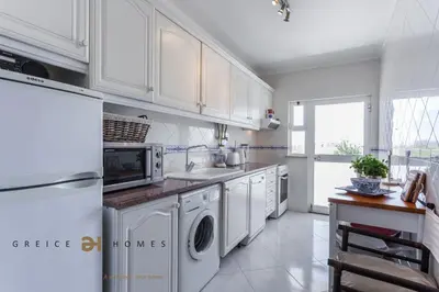 a kitchen with white cabinets and a washer and dryer at T1 Grevilias em Vilamoura - Greice Homes in Quarteira