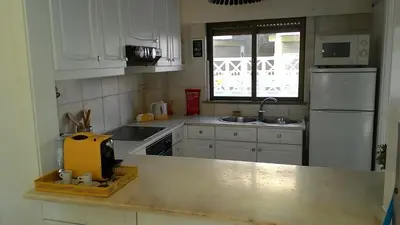 a kitchen with white cabinets and a yellow appliance on a counter at Apartamento Oura T1 Beach 200m in Albufeira