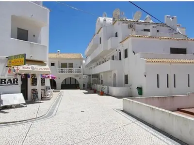 a large white building with a walkway in front of it at Apartamento Oura T1 Beach 200m in Albufeira