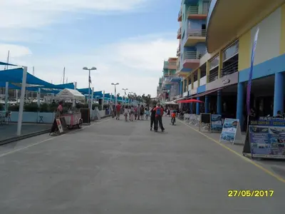 a group of people walking down a street next to buildings at Marina Luxury Residence - Albufeira in Albufeira