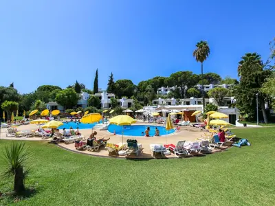 a group of people sitting in chairs at a pool at Luxury 3 Bedroom Apartment, Albufeira Resort in Albufeira