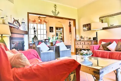 a living room with red chairs and a table at Faro Beach House in Faro