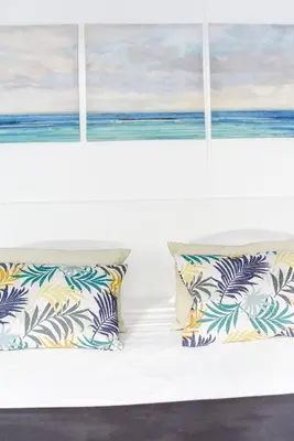 a bed with pillows and a window with the ocean at Casas Barulho Penthouse Old Town in Albufeira