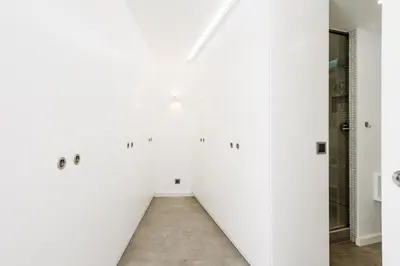 a hallway with white walls and a tile floor at Casas Barulho Penthouse Old Town in Albufeira