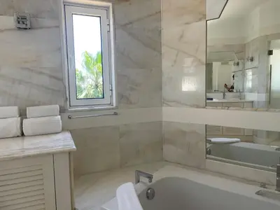 a bathroom with a tub and a sink and a mirror at Vila Marine in Albufeira