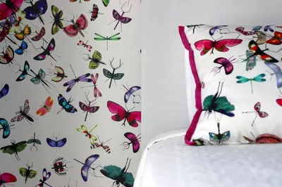 a pillow with butterflies on a wall at L&F House in Algoz