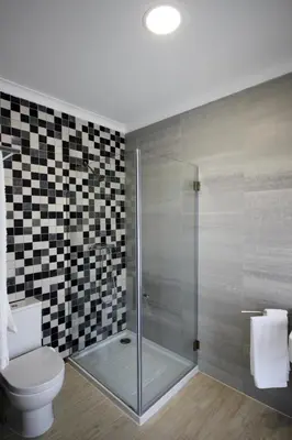a bathroom with a toilet and a glass shower at L&F House in Algoz