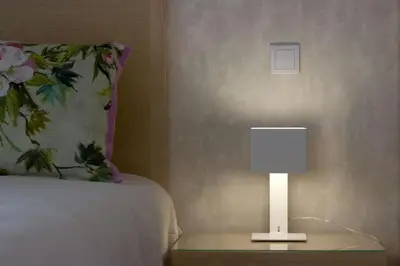 a lamp on a night stand next to a bed at L&F House in Algoz