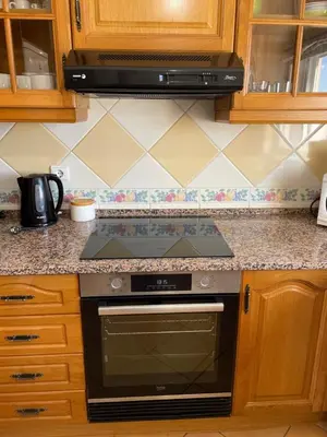 a stove top oven in a kitchen with wooden cabinets at Palm Garden in Vilamoura