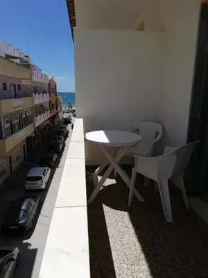 a table and chairs on the balcony of a building at Apartamentos Arcada in Quarteira
